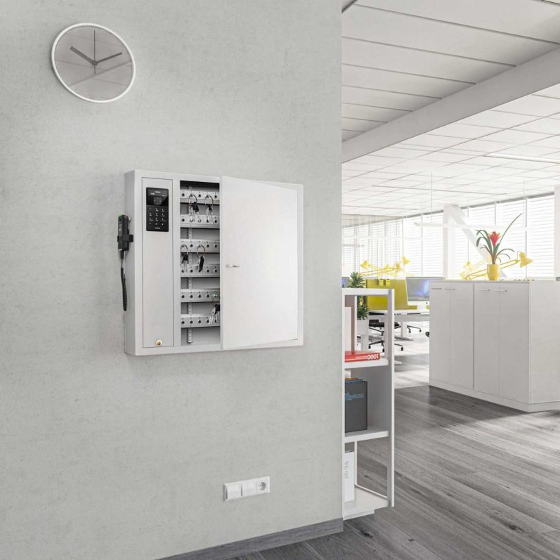 CREONE Keycontrol 9500 SC avec éthylotest Armoire à clés blanche sur un mur gris dans un bureau moderne. Horloge au-dessus.